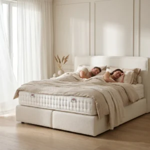 Paar schläft ruhig und erholt in einem Boxspringliebe-Naturbett, helles luftiges Schlafzimmer